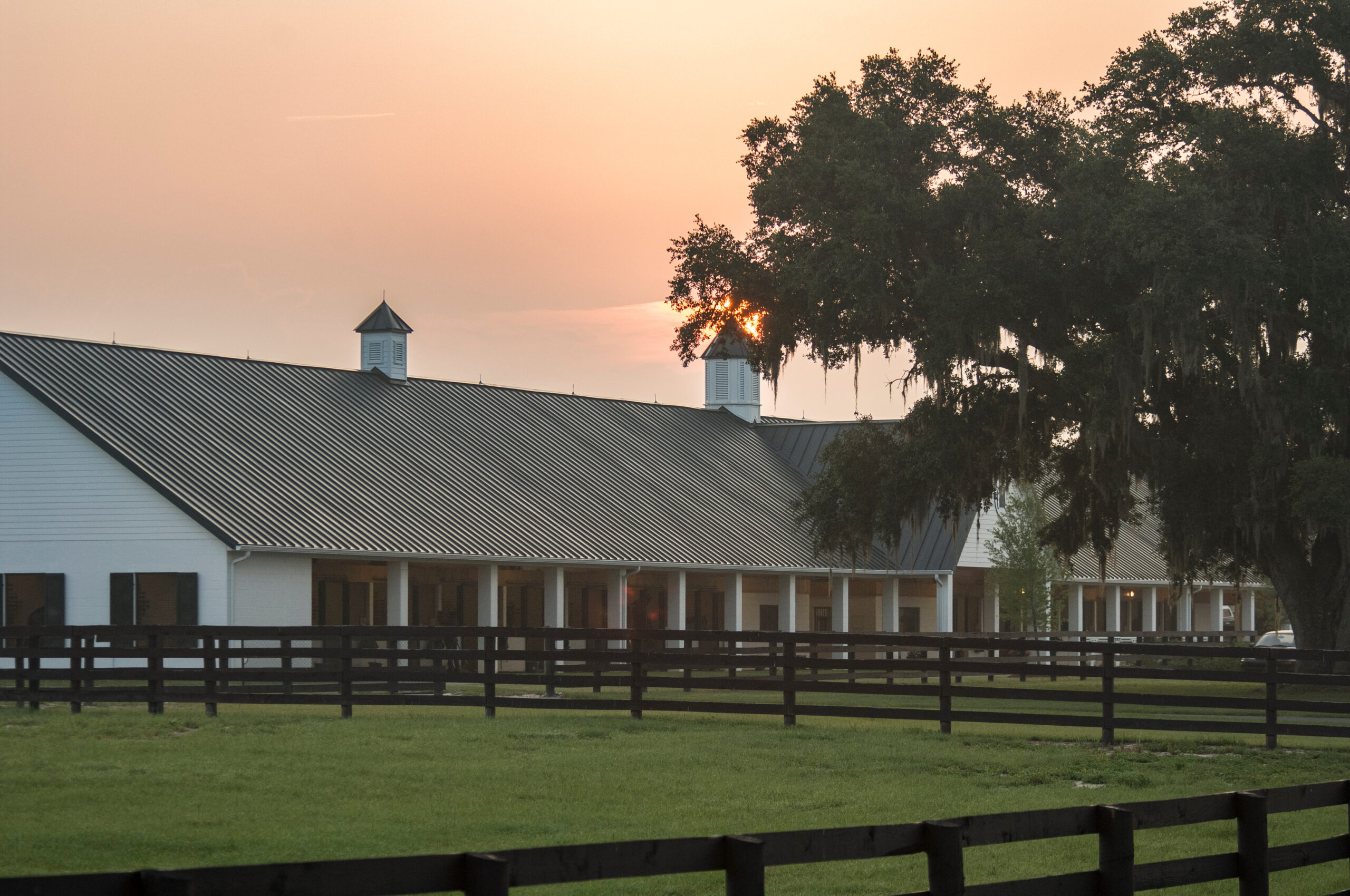 Sunrise over upscale horse barn facility