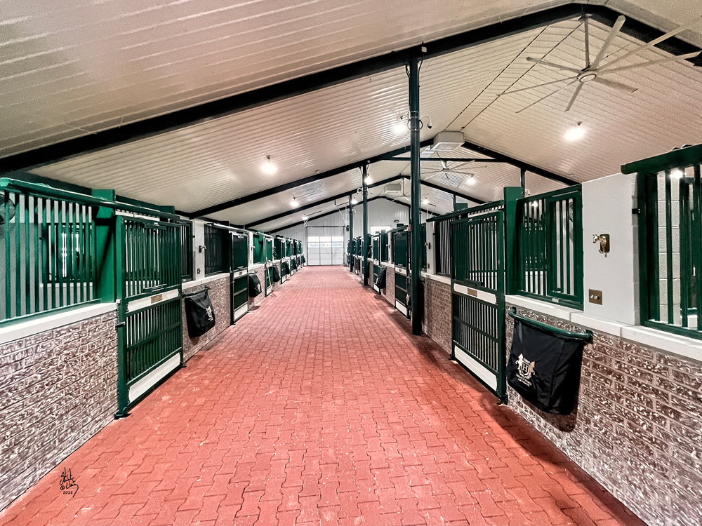 Barn interior with sliding door stalls with yoke and rubber pavers